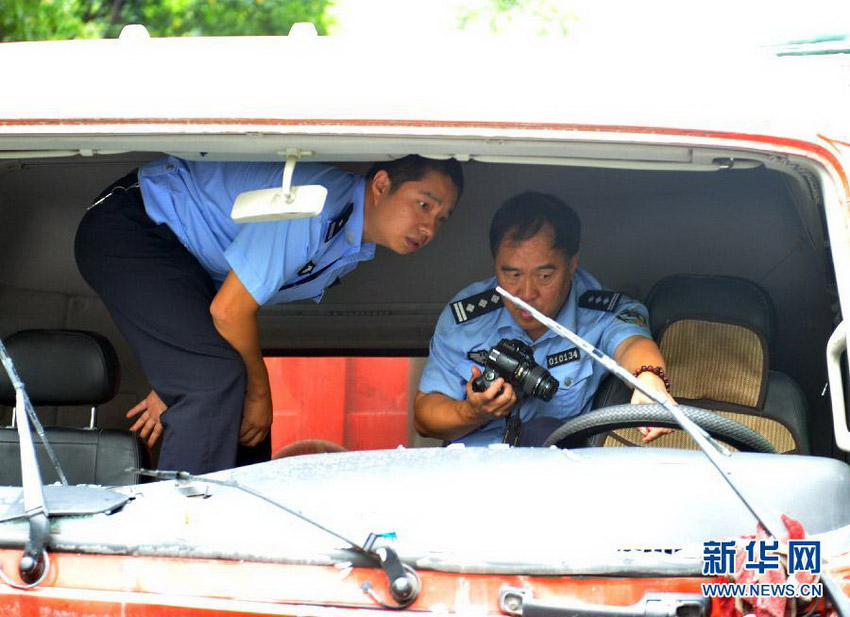 几名交警部门和司法鉴定部门的技术人员正在针对事故车辆在公路上留下的痕迹进行技术勘察（8月20日摄）。 