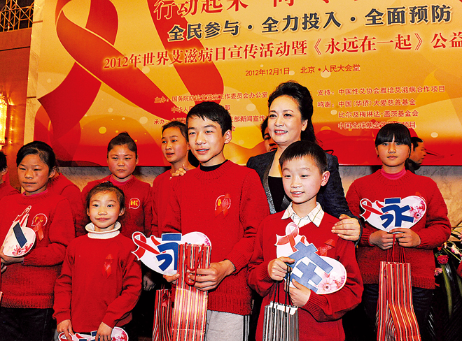 昨日，彭丽媛与参与公益短片《永远在一起》的青少年一起参加世界艾滋病日宣传活动。 新华社发.jpg