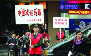 12月1日，广东边防七支队官兵在深圳市繁华路段举着标语，倡导市民文明过马路 新华社发（廖键 摄）