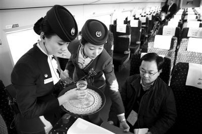 昨日,京广高铁试跑。在列车上,乘务员正给乘客倒水。 本版摄影/新京报记者 尹亚飞 摄 昨日,京广高铁试跑。在列车上,乘务员正给乘客倒水。 本版摄影/新京报记者 尹亚飞 摄
