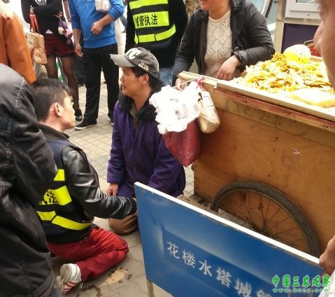 小贩车被扣下跪求情 城管为防误会与其“对跪”