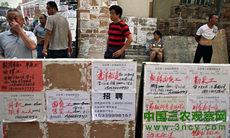 失业农民工聚集于中国东部青岛市劳务市场求职广告前。照片: 吴宏/欧新社