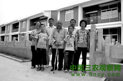 ③2011年6月27日下午，何兆胜（中）抵达新居后和家人的合影。 淅川县委宣传部供图