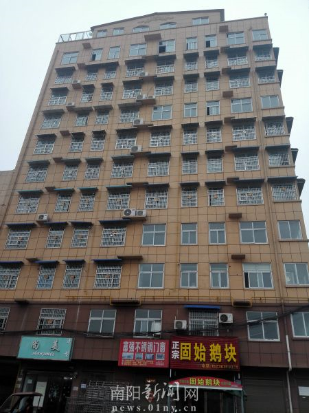 图为:位于河南省信阳市红旗渠大道中段与中石化铁路专线平交口处的12层“大牛楼盘”